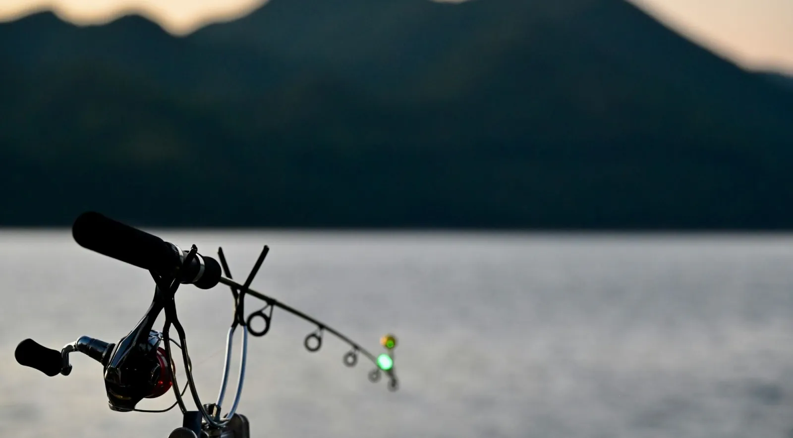 A fishing rod against a Lofoten fjord at dusk
