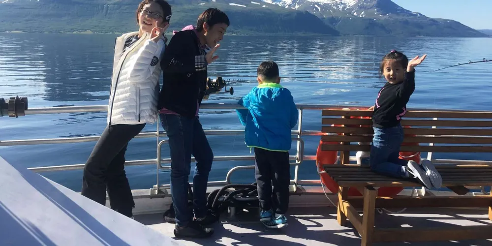 A family fishing from the boat on a Tromsø Arctic fjord cruise