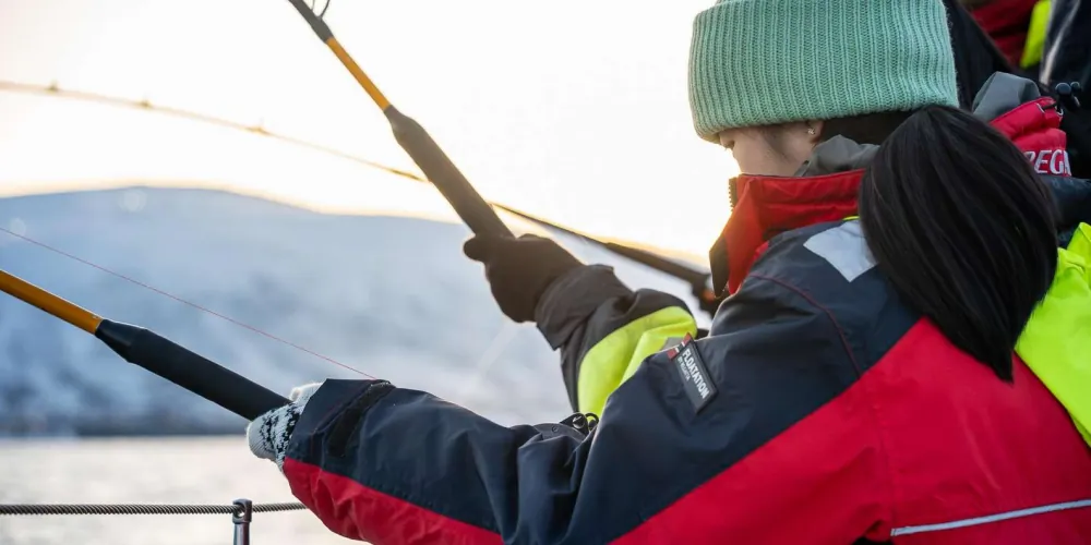 Anglers working their rods at sunset on the Arctic sea safari